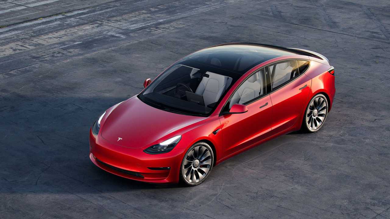 Red Tesla Model 3 on a winding road